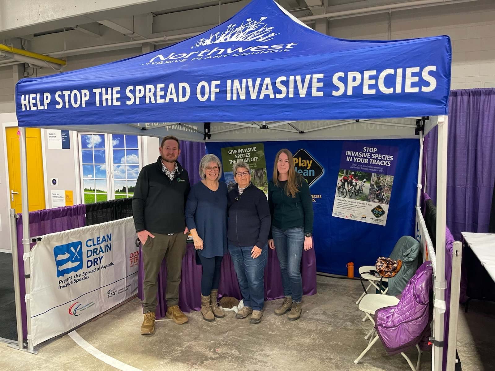 group of individuals under blue tent at a tradeshow